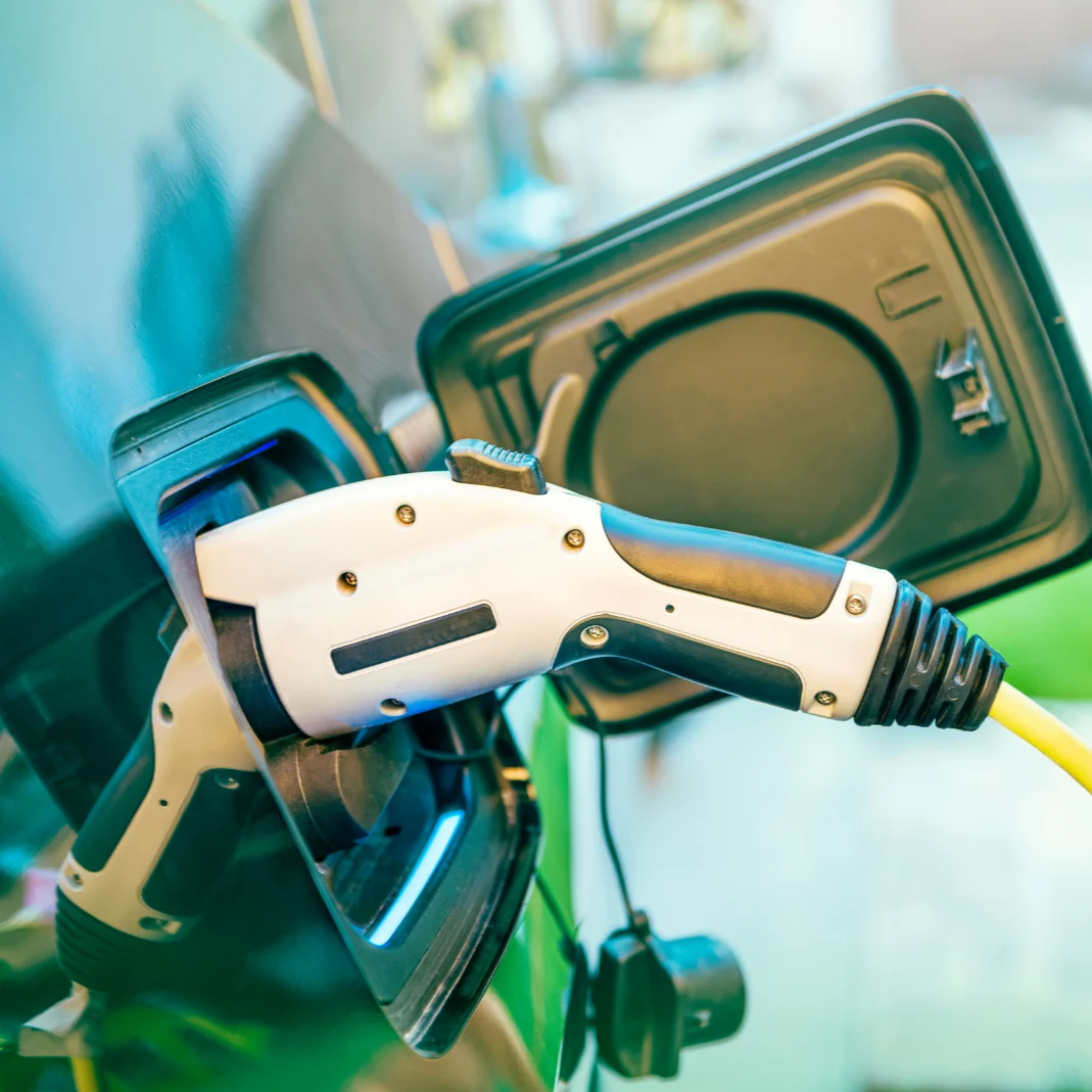 Close-up of an electric vehicle charging cable connected to a charging port.
