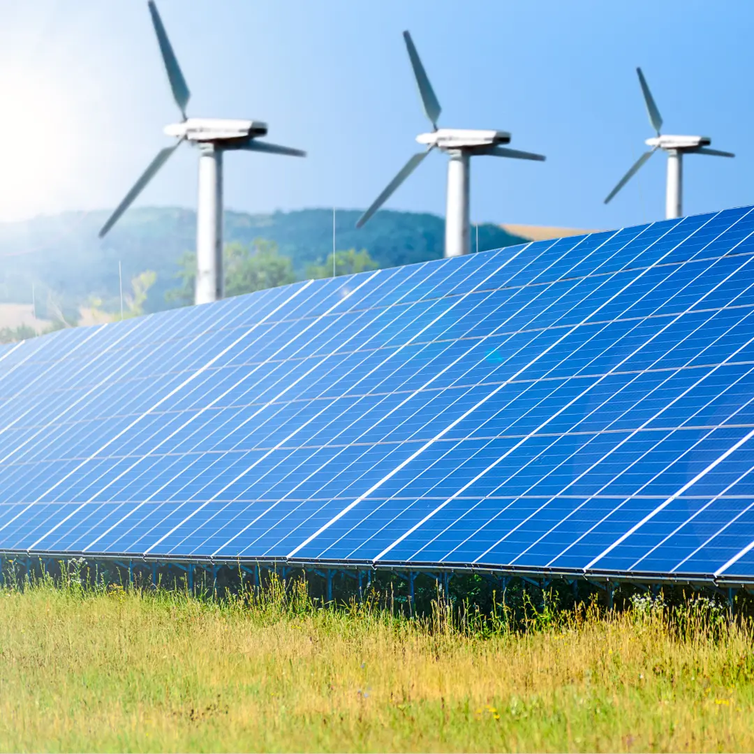 Rows of solar panels with wind turbines in the background, symbolizing renewable energy.